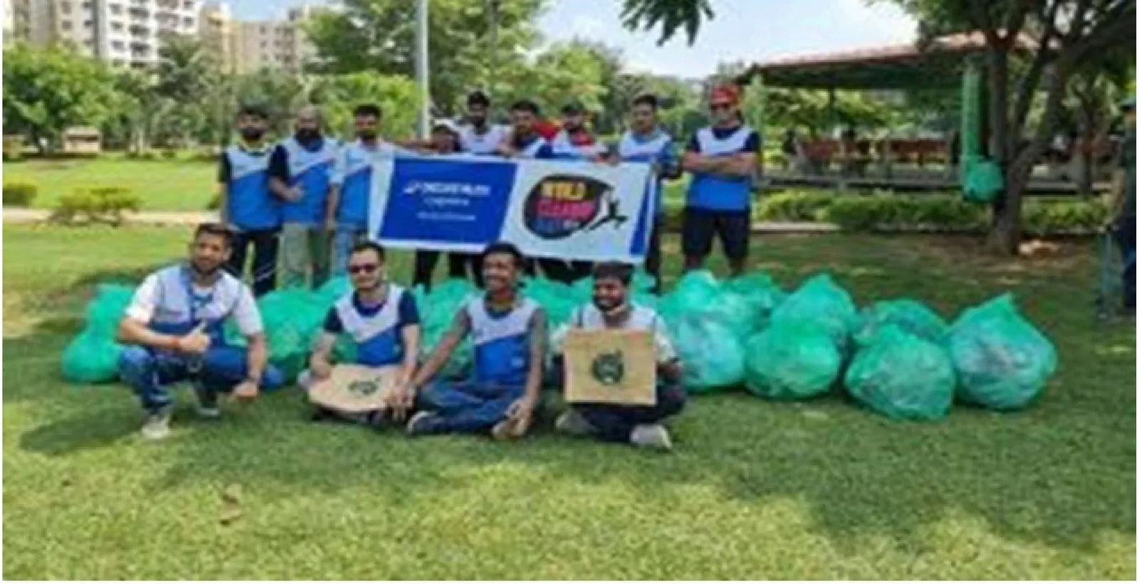 Corporate volunteers in team jerseys with collected bags after a plogging drive