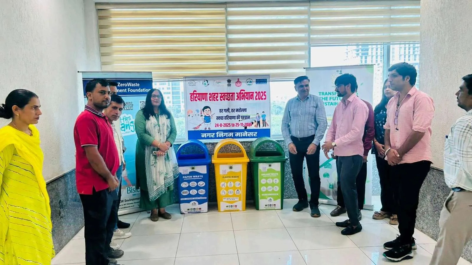 People standing beside a row of colour-coded bins and banners